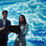 büyük dijital beyin ağı görseli önünde dizüstü bilgisayarlarla çalışan iki profesyonel, yapay zekâ kullanan şirketler ve kurumsal AI analizi konsepti